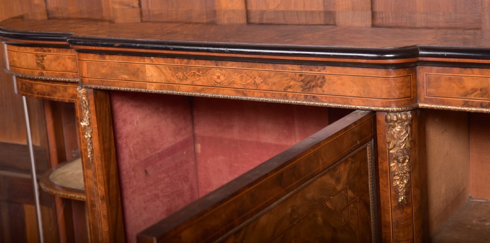 A Victorian burr walnut credenza featuring a central inlaid cupboard door flanked by curved glass display sections with gilt-bronze mounts. View X