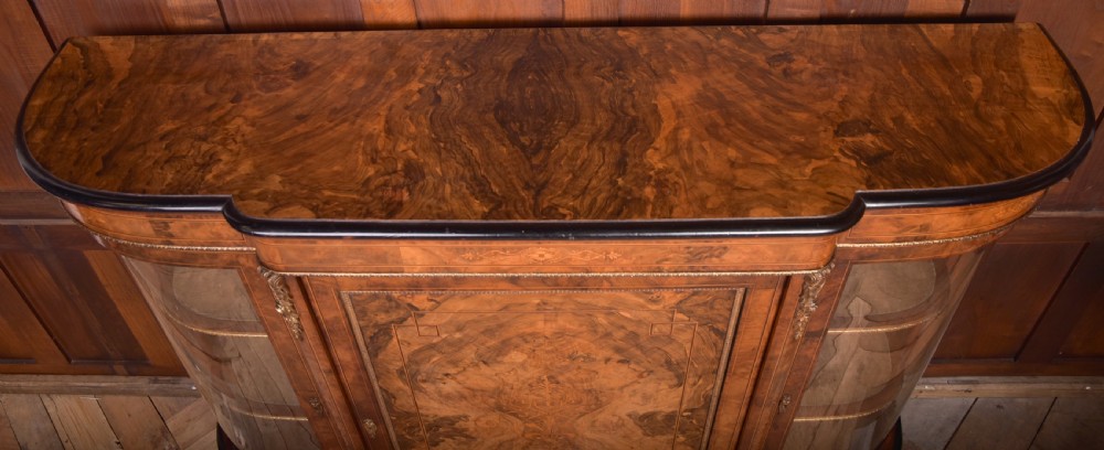 A Victorian burr walnut credenza featuring a central inlaid cupboard door flanked by curved glass display sections with gilt-bronze mounts. View XI