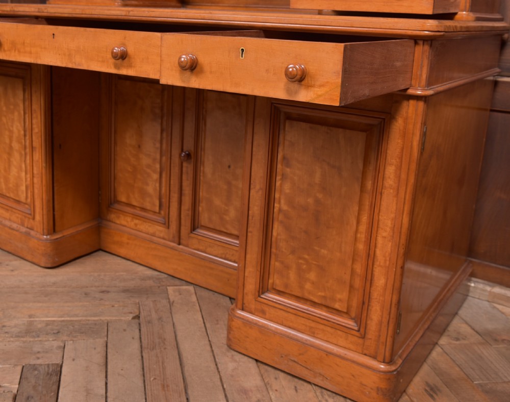 A Victorian satinwood dressing table featuring an arched central swivel mirror, trinket drawers, frieze drawers, and lower pedestal cupboards. View VIII
