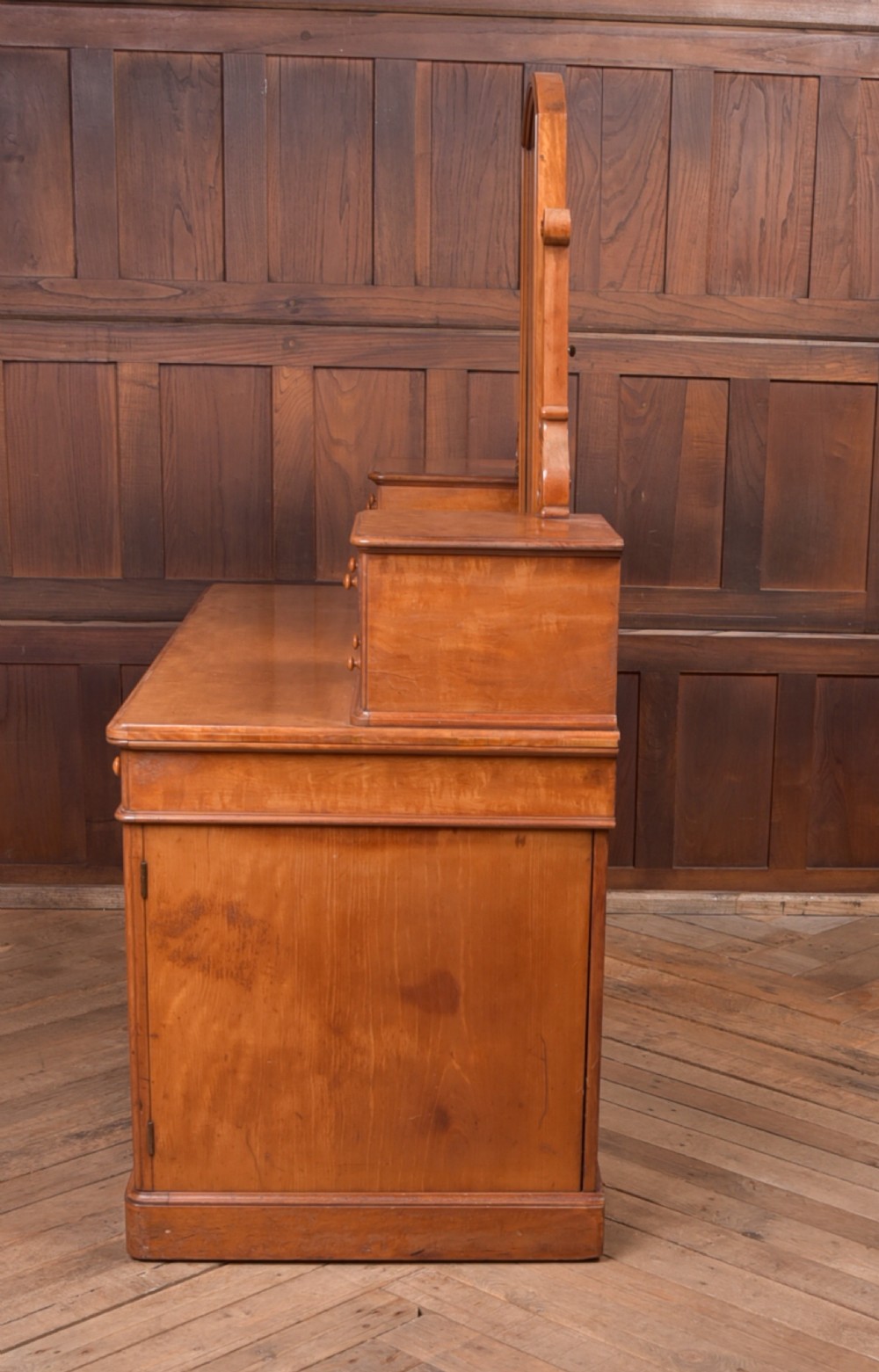 A Victorian satinwood dressing table featuring an arched central swivel mirror, trinket drawers, frieze drawers, and lower pedestal cupboards. View IX