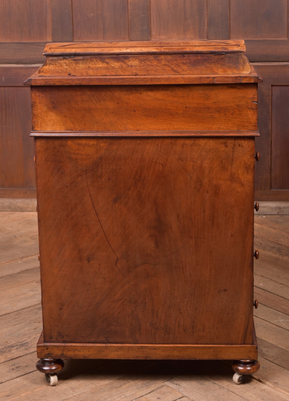 A Victorian burr walnut Davenport desk featuring a slanted leather writing surface, decorative carved supports, and a side bank of drawers. View VIII