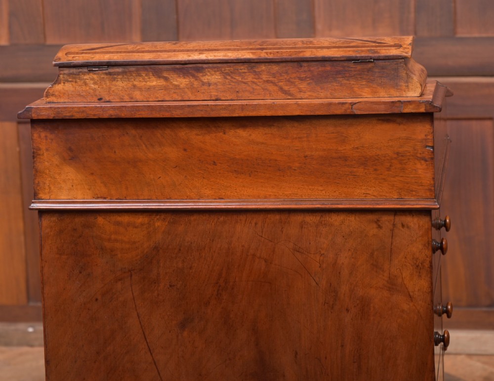 A Victorian burr walnut Davenport desk featuring a slanted leather writing surface, decorative carved supports, and a side bank of drawers. View IX