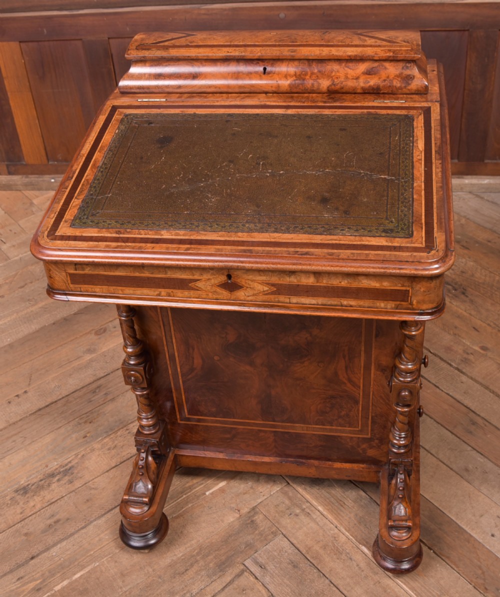 A Victorian burr walnut Davenport desk featuring a slanted leather writing surface, decorative carved supports, and a side bank of drawers. View XIII