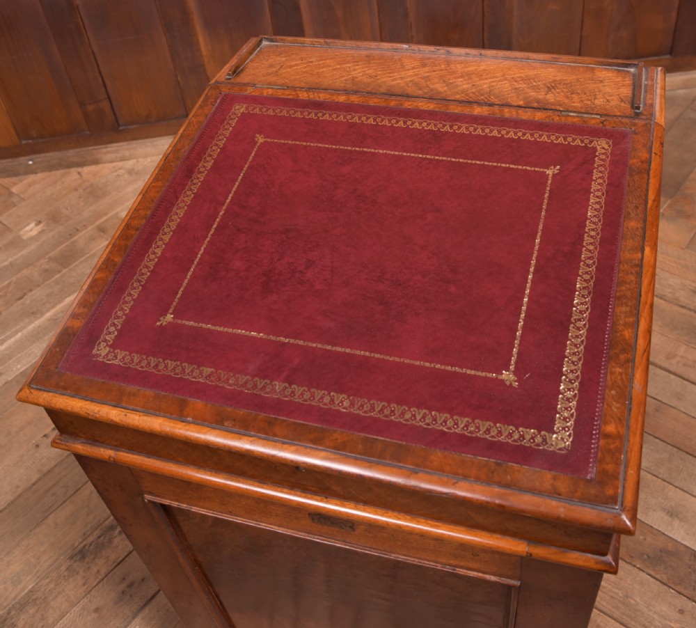A Victorian walnut Davenport desk featuring a slanted burgundy leather writing surface, side drawers with wooden knobs, and a solid rectangular base. View II