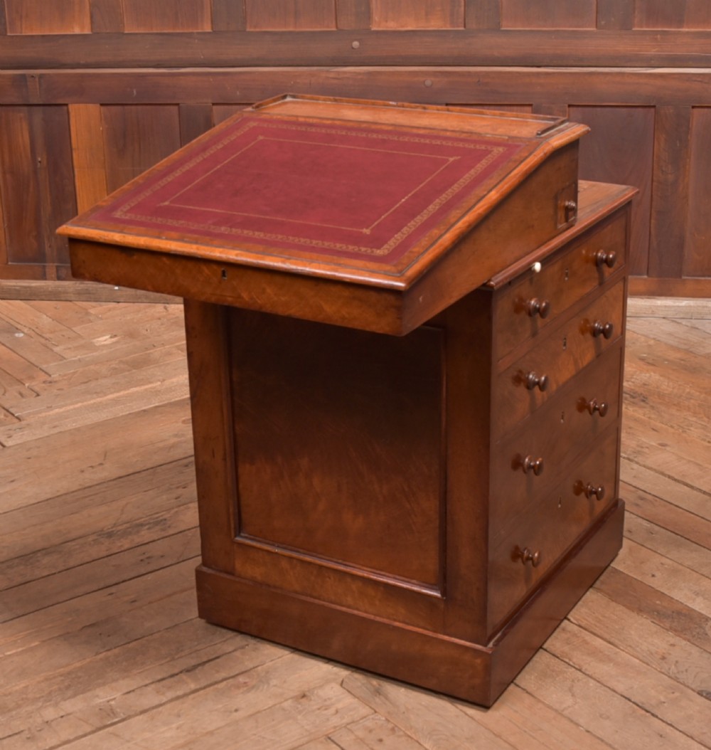 A Victorian walnut Davenport desk featuring a slanted burgundy leather writing surface, side drawers with wooden knobs, and a solid rectangular base. View III