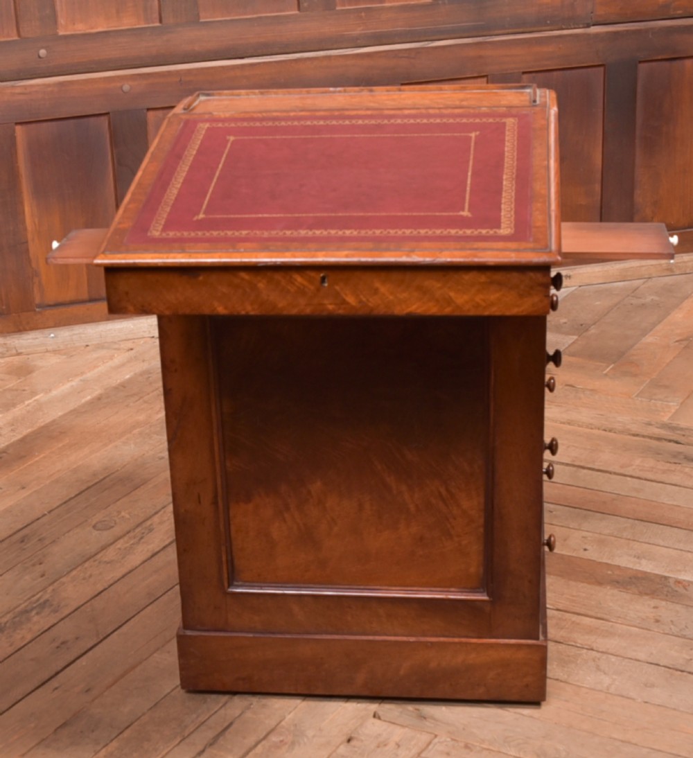 A Victorian walnut Davenport desk featuring a slanted burgundy leather writing surface, side drawers with wooden knobs, and a solid rectangular base. View V
