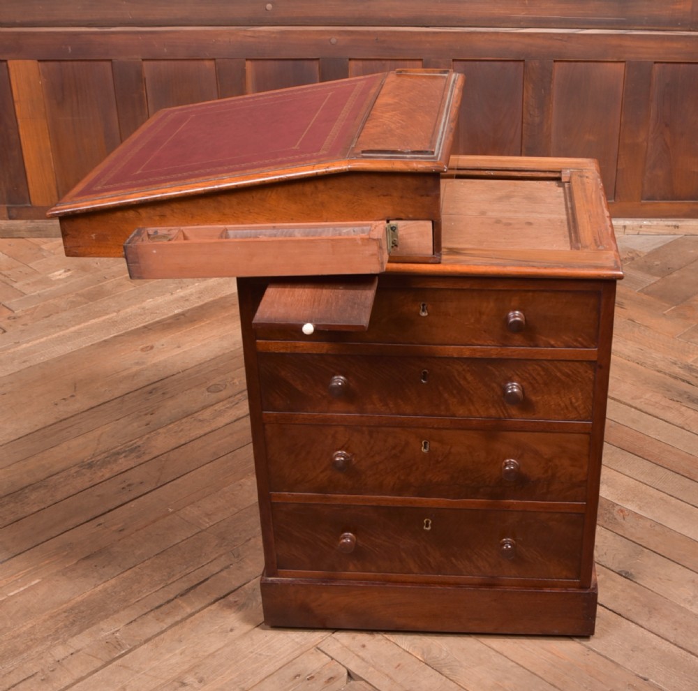 A Victorian walnut Davenport desk featuring a slanted burgundy leather writing surface, side drawers with wooden knobs, and a solid rectangular base. View IX