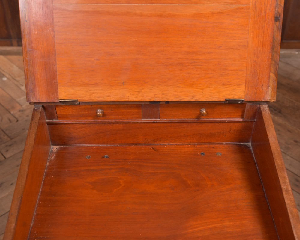A Victorian walnut Davenport desk featuring a slanted burgundy leather writing surface, side drawers with wooden knobs, and a solid rectangular base. View XV