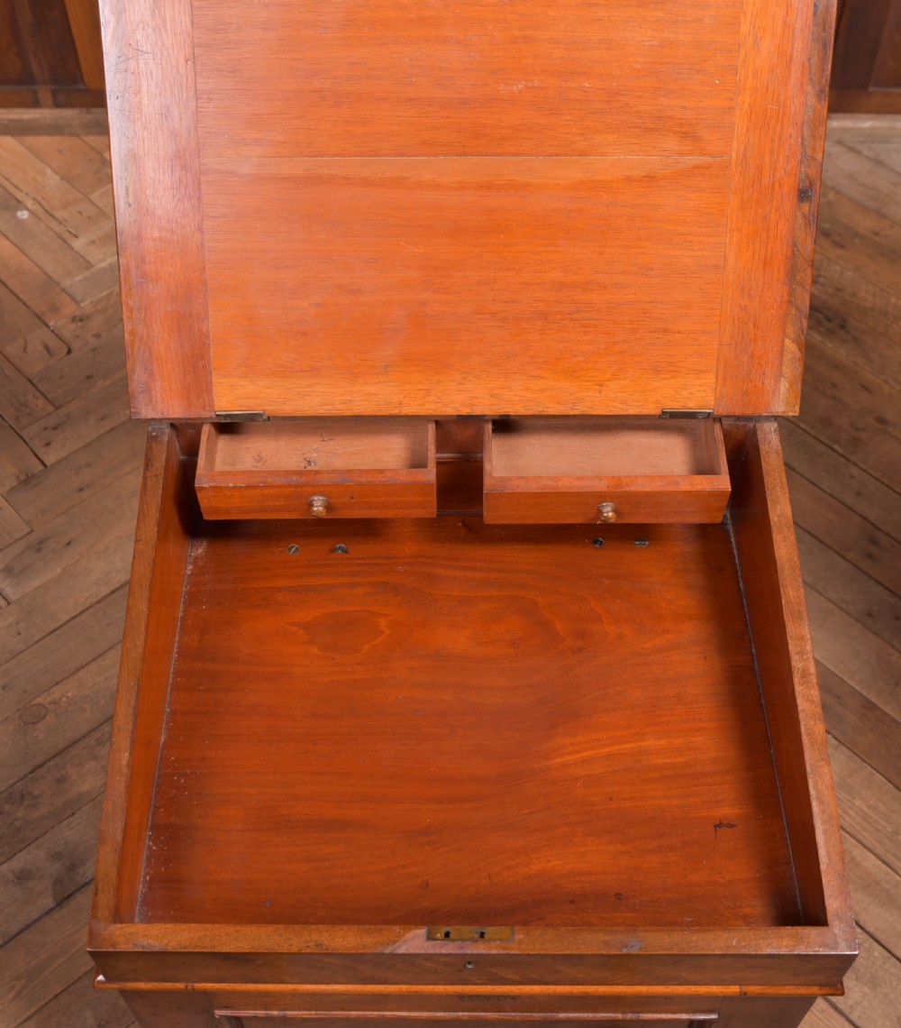 A Victorian walnut Davenport desk featuring a slanted burgundy leather writing surface, side drawers with wooden knobs, and a solid rectangular base. View XVII