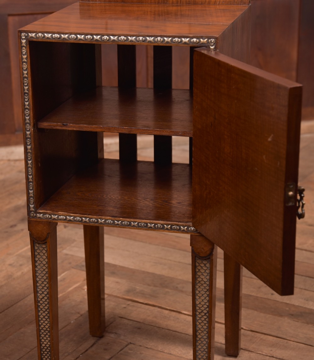 An antique walnut bedside cabinet featuring a single door panel with burr walnut veneer, beaded metal trim, a top splashback upstand, and four square tapered legs. View III