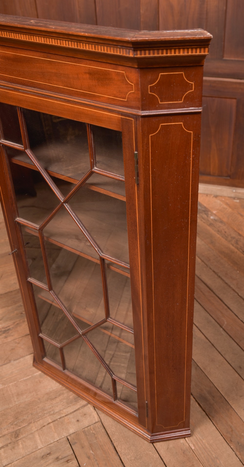 An Edwardian mahogany corner cabinet featuring astragal glazed glass panels, geometric boxwood line inlay, and internal timber shelves. View II