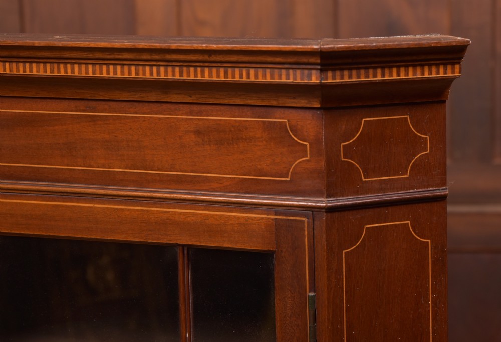 An Edwardian mahogany corner cabinet featuring astragal glazed glass panels, geometric boxwood line inlay, and internal timber shelves. View III