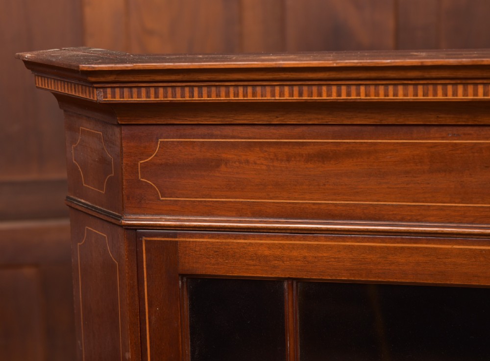 An Edwardian mahogany corner cabinet featuring astragal glazed glass panels, geometric boxwood line inlay, and internal timber shelves. View V