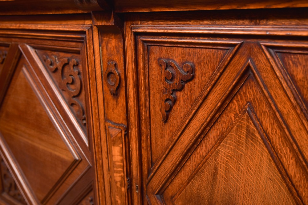 A large Victorian oak bookcase featuring glazed upper doors flanked by barley twist columns with turned finials above carved diamond panel doors. View XII