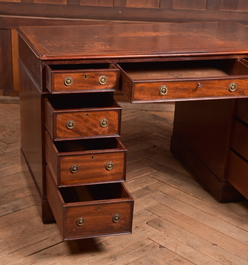 An Edwardian mahogany pedestal desk with nine drawers, brass ring handles, and a leather-inset writing surface. View VIII