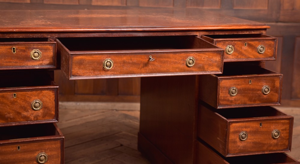 An Edwardian mahogany pedestal desk with nine drawers, brass ring handles, and a leather-inset writing surface. View XI