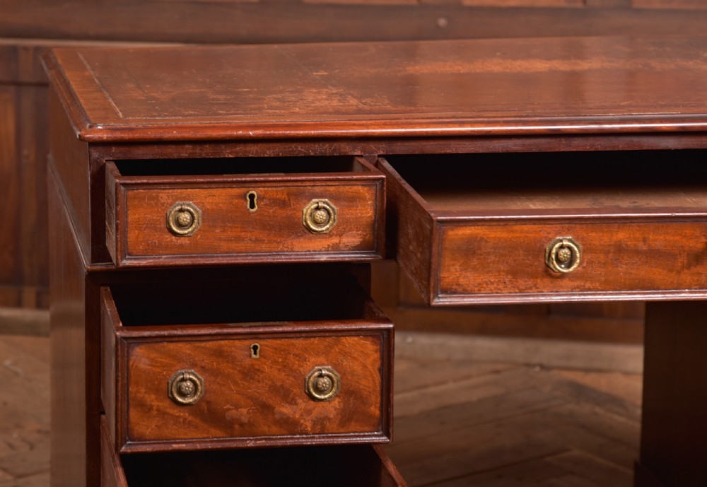 An Edwardian mahogany pedestal desk with nine drawers, brass ring handles, and a leather-inset writing surface. View XIII