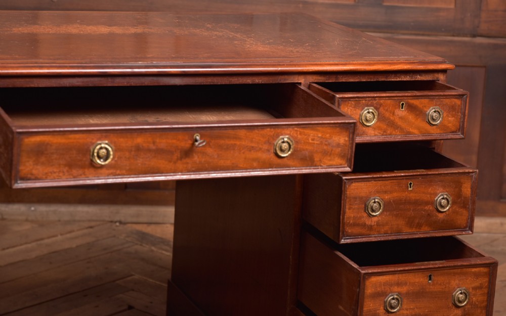 An Edwardian mahogany pedestal desk with nine drawers, brass ring handles, and a leather-inset writing surface. View XIV