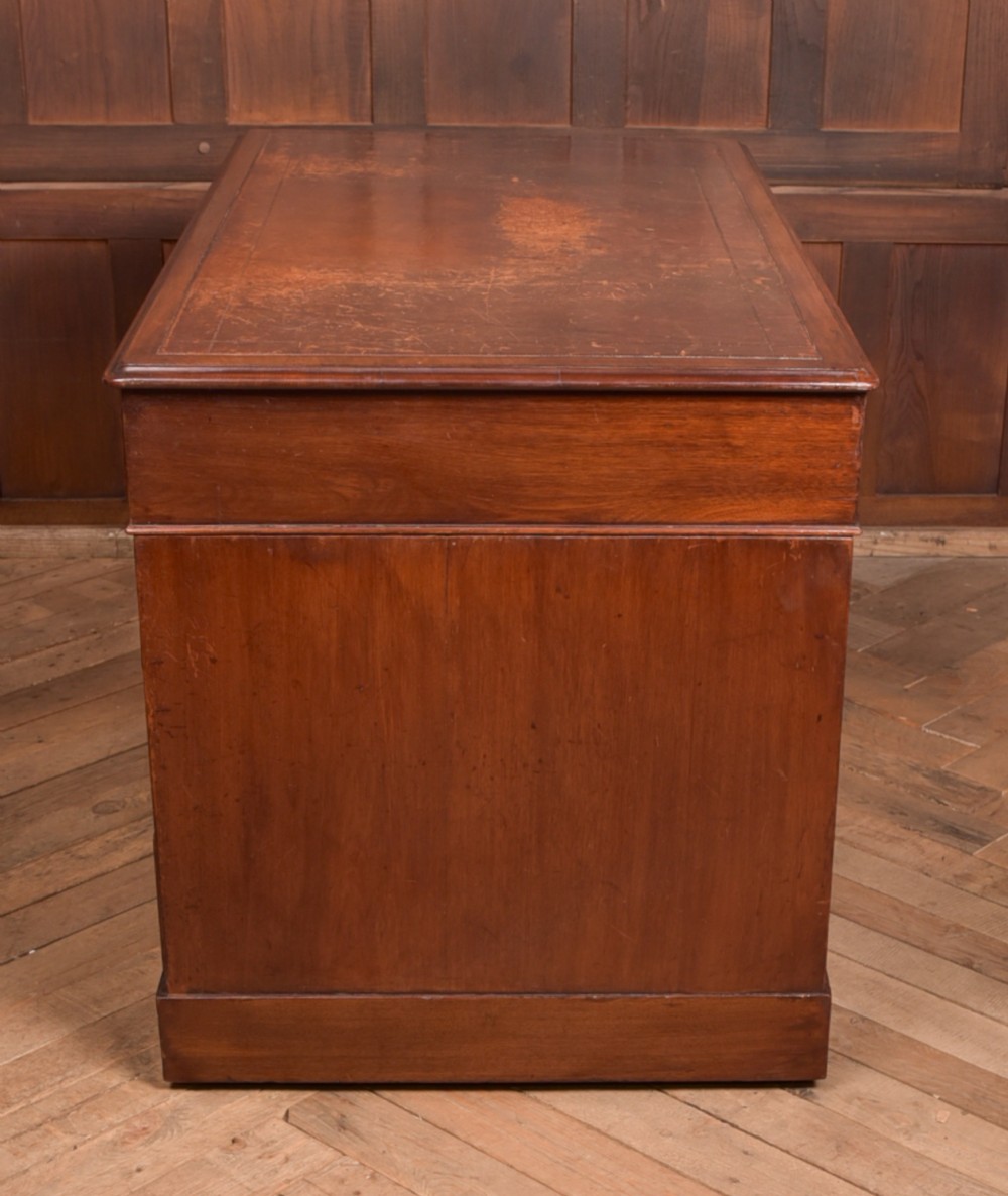 An Edwardian mahogany pedestal desk with nine drawers, brass ring handles, and a leather-inset writing surface. View XVI