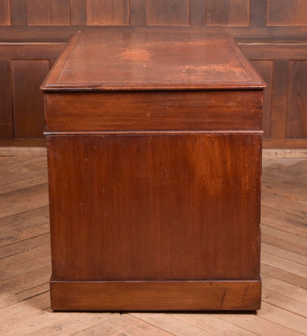 An Edwardian mahogany pedestal desk with nine drawers, brass ring handles, and a leather-inset writing surface. View XX