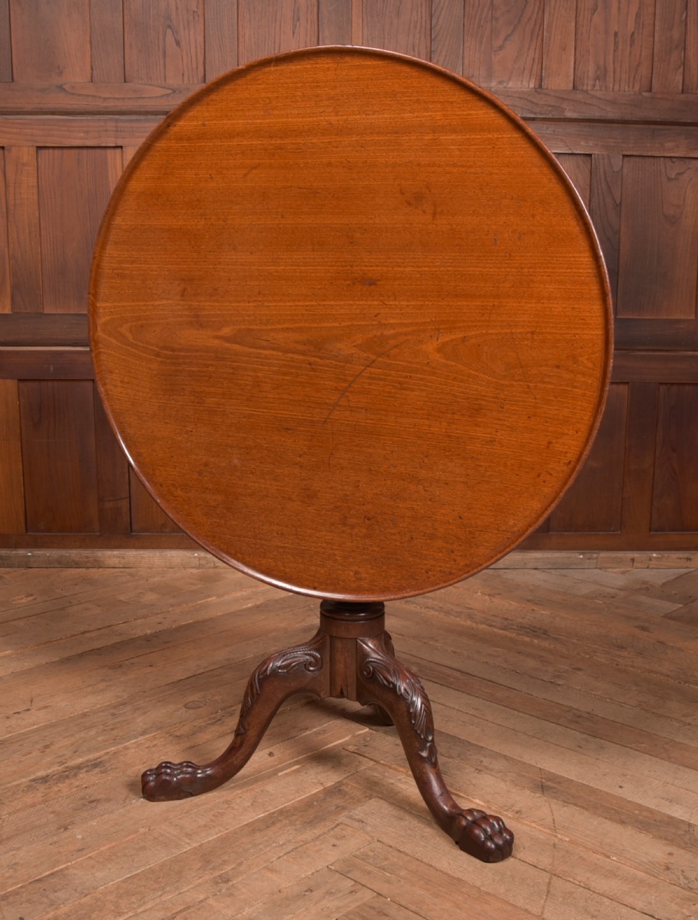 A Georgian mahogany circular snap-top supper table displayed vertically on a turned pedestal stem with carved cabriole legs and ball-and-claw feet. View III