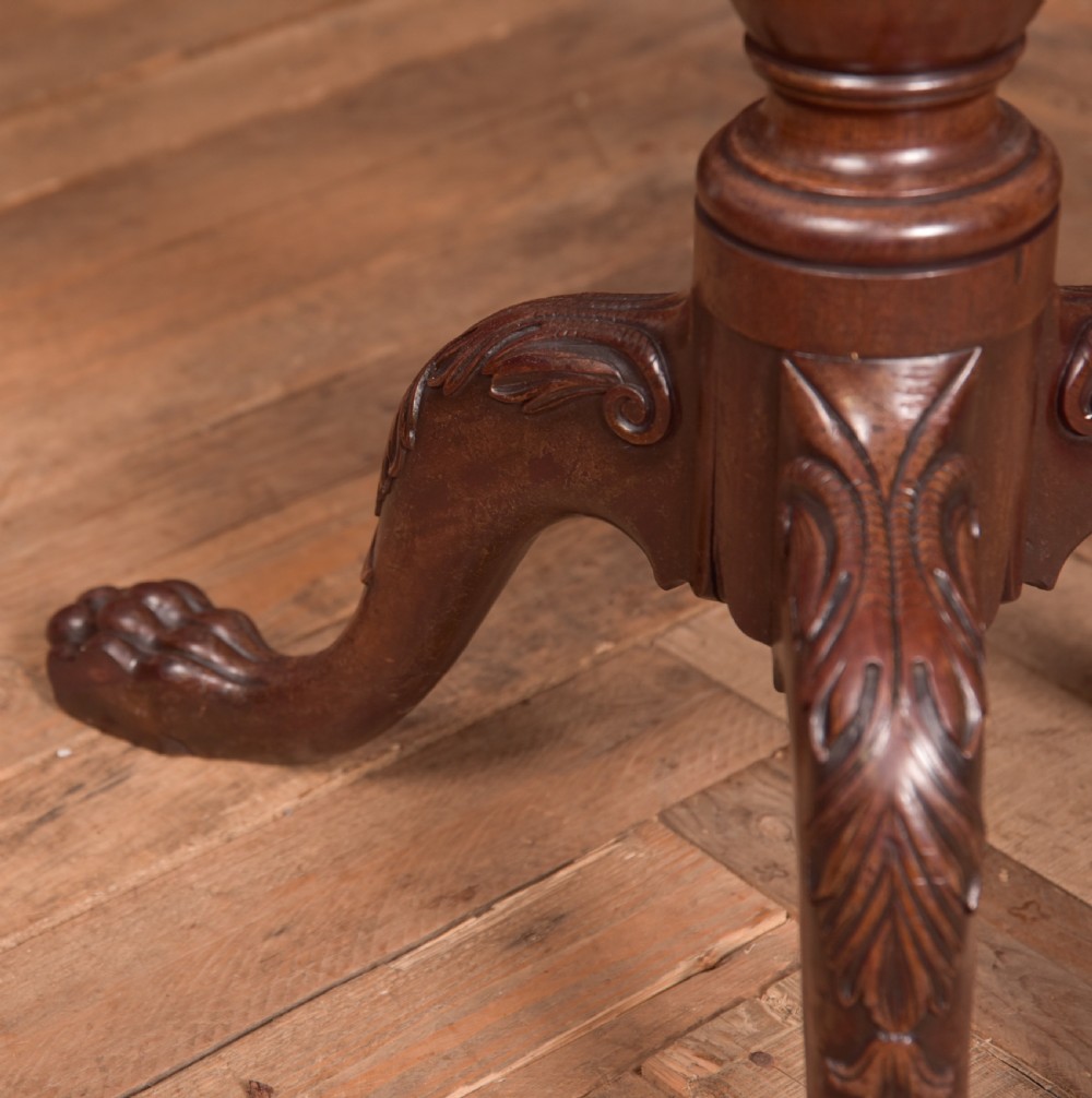 A Georgian mahogany circular snap-top supper table displayed vertically on a turned pedestal stem with carved cabriole legs and ball-and-claw feet. View IX