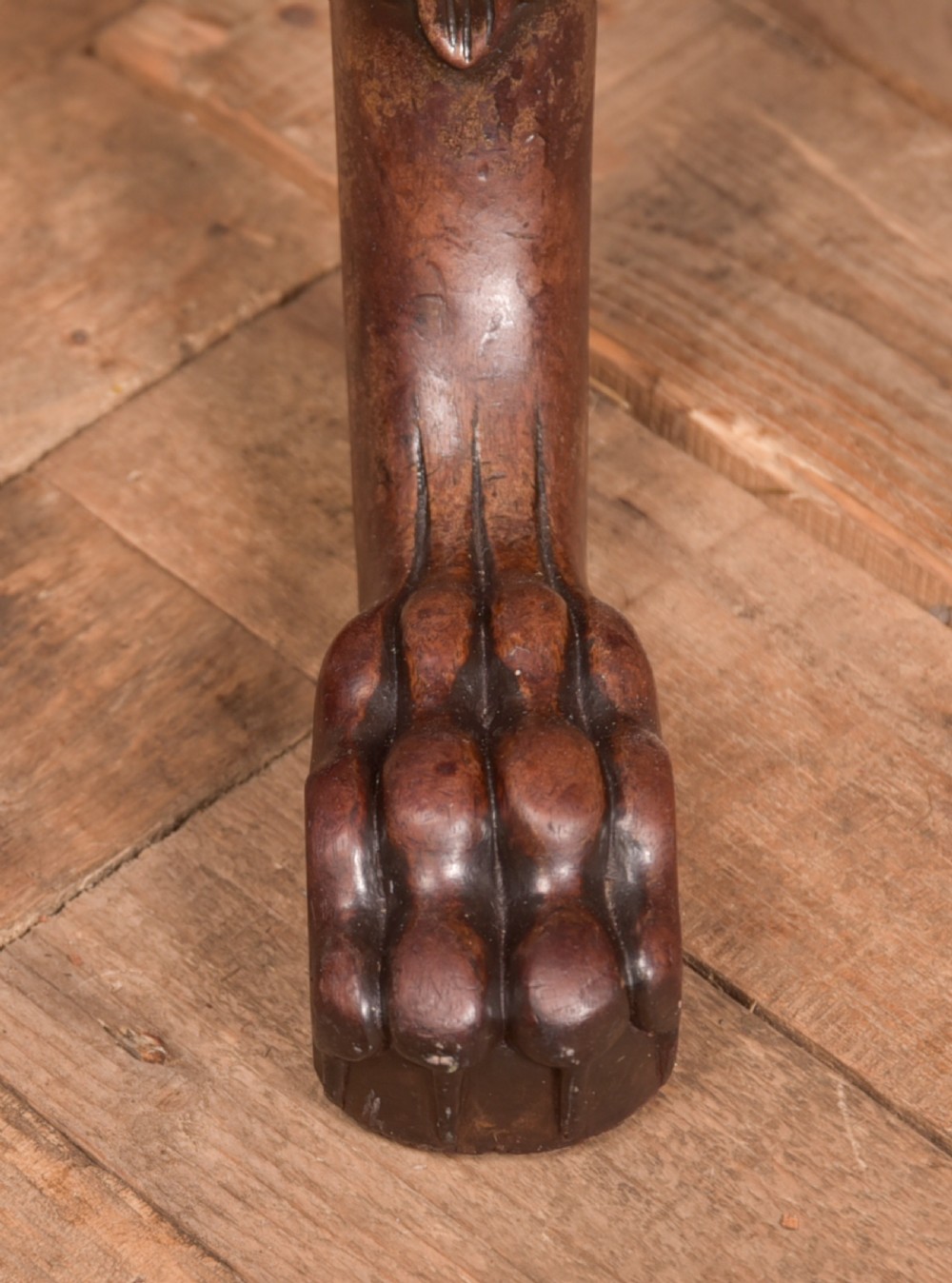 A Georgian mahogany circular snap-top supper table displayed vertically on a turned pedestal stem with carved cabriole legs and ball-and-claw feet. View X