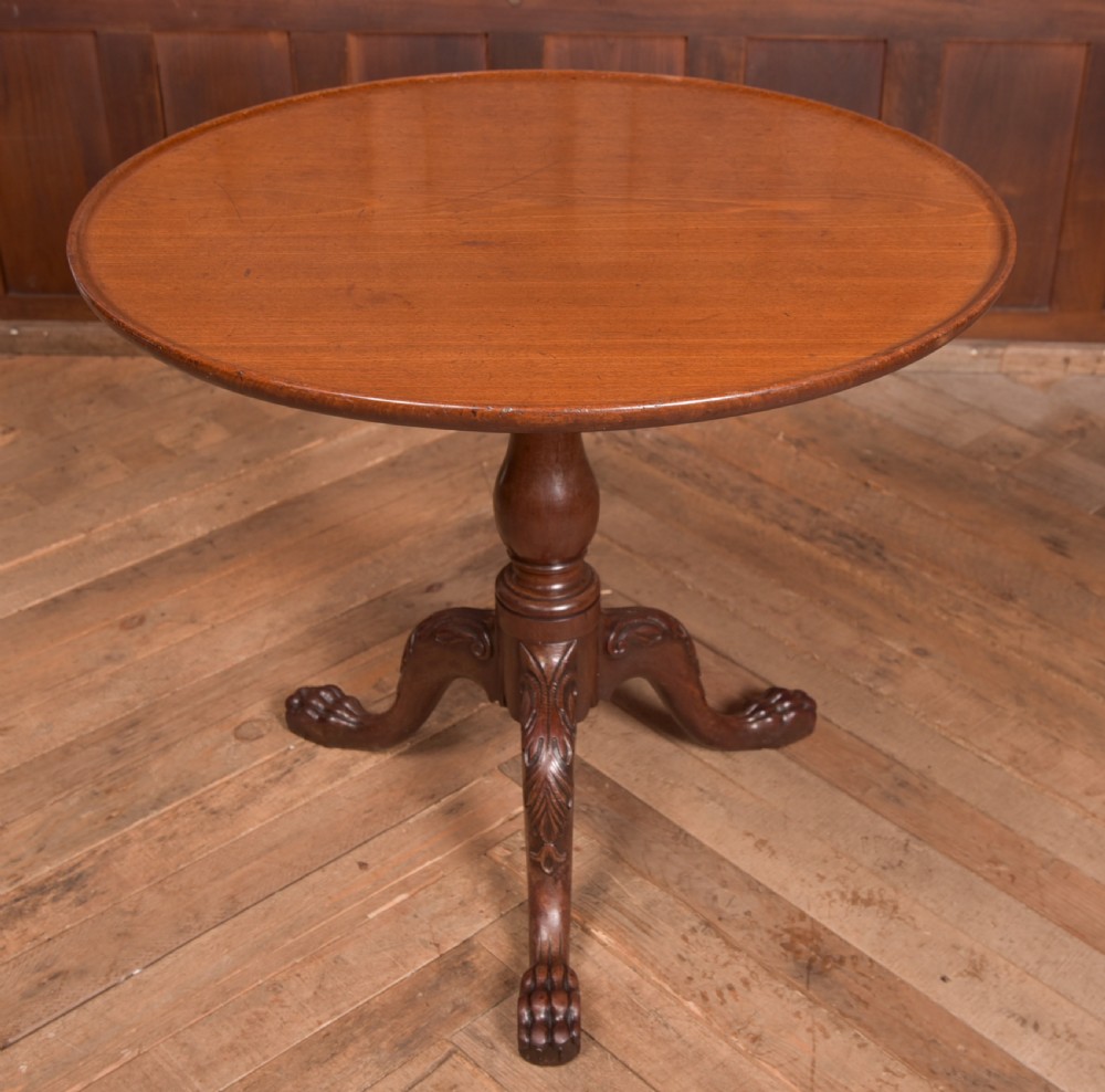 A Georgian mahogany circular snap-top supper table displayed vertically on a turned pedestal stem with carved cabriole legs and ball-and-claw feet. View XI