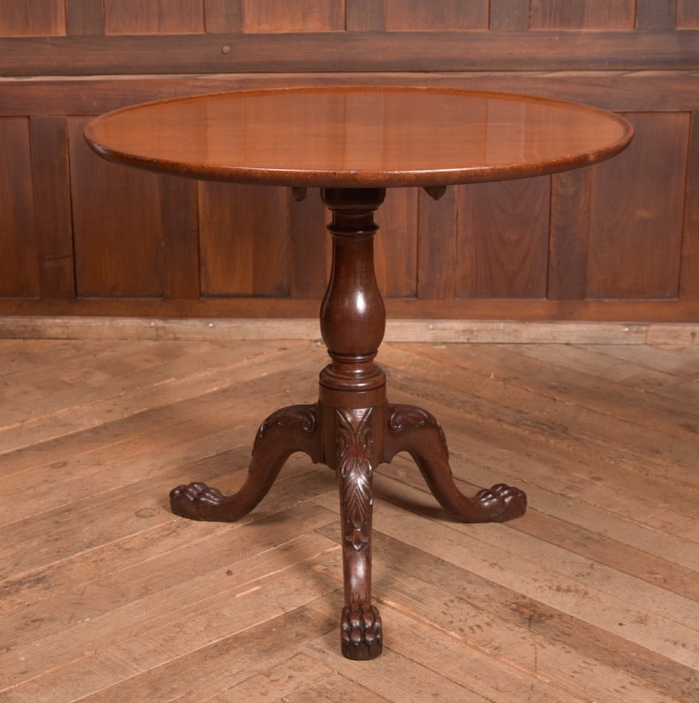 A Georgian mahogany circular snap-top supper table displayed vertically on a turned pedestal stem with carved cabriole legs and ball-and-claw feet. View XII