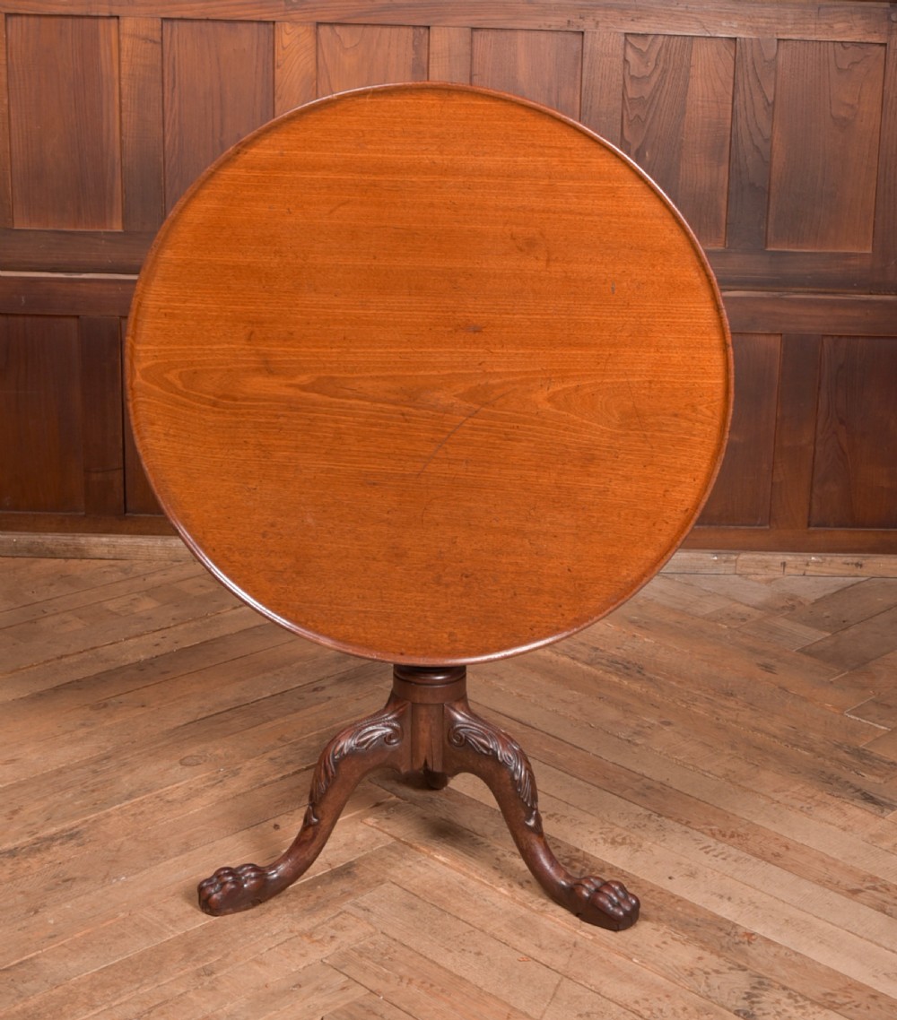 A Georgian mahogany circular snap-top supper table displayed vertically on a turned pedestal stem with carved cabriole legs and ball-and-claw feet. View XIII