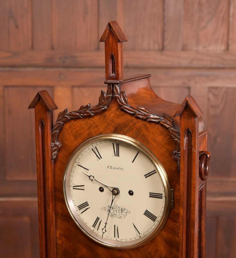 An antique mahogany bracket clock featuring Gothic spire finials, a carved foliage crest, and a cream dial signed Christie Perth set within a brass bezel. View II