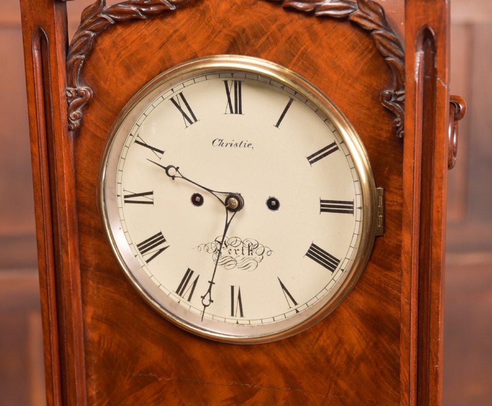 An antique mahogany bracket clock featuring Gothic spire finials, a carved foliage crest, and a cream dial signed Christie Perth set within a brass bezel. View V