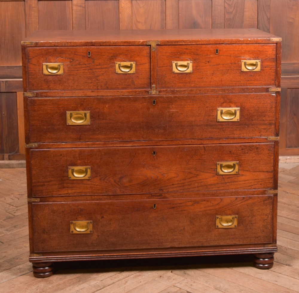A nineteenth-century teak military campaign chest of drawers with flush brass handles, corner brackets, and turned feet. View VII