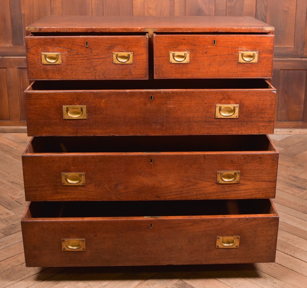 A nineteenth-century teak military campaign chest of drawers with flush brass handles, corner brackets, and turned feet. View XIV