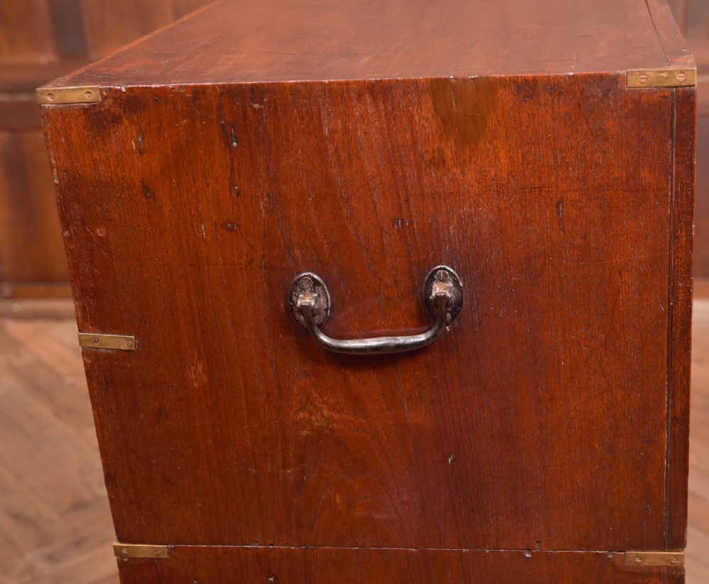 A nineteenth-century teak military campaign chest of drawers with flush brass handles, corner brackets, and turned feet. View XVIII