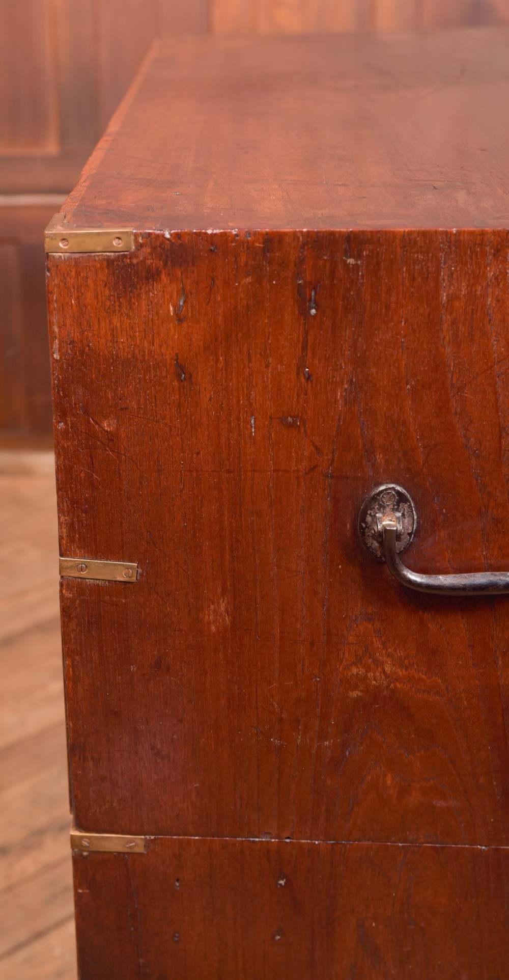 A nineteenth-century teak military campaign chest of drawers with flush brass handles, corner brackets, and turned feet. View XIX