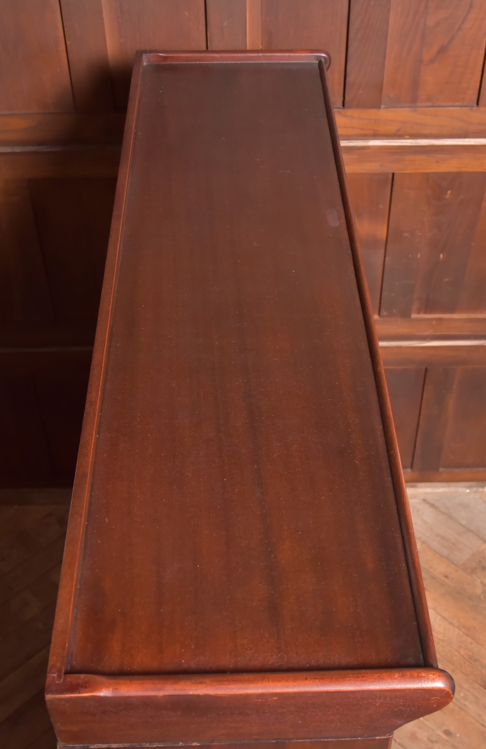 A large double-width mahogany sectional bookcase featuring three tiers of glazed lift-up doors filled with antique books above a solid wooden double cupboard base. View XVI