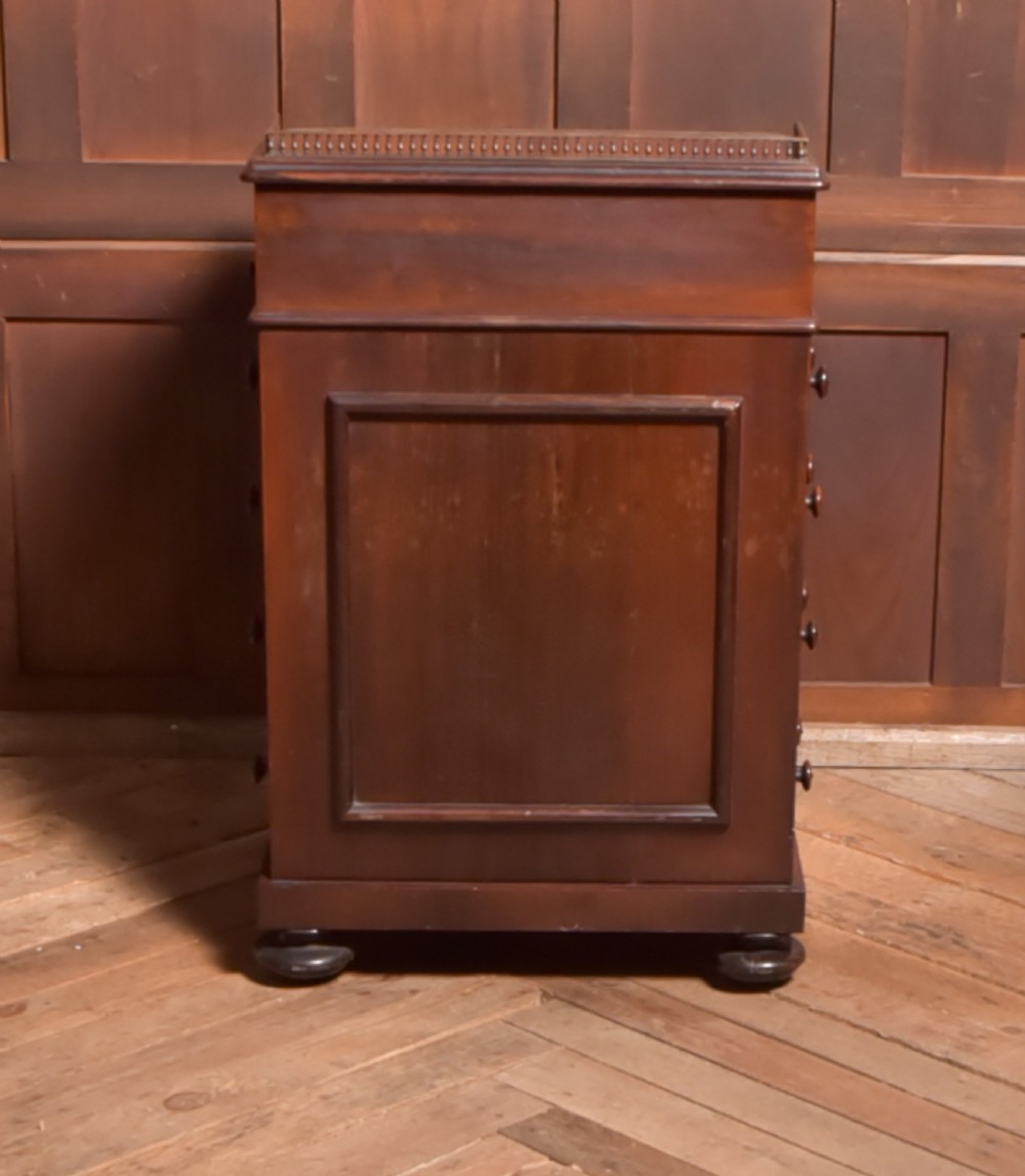 A Victorian rosewood Davenport desk featuring a slanted leather-inset writing surface, brass gallery rail, turned front columns, and side drawers. View XII