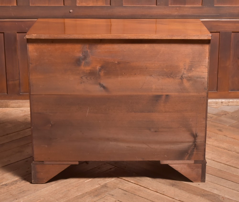 An antique Georgian mahogany kneehole desk featuring seven drawers with brass batwing handles, a recessed central cupboard, and shaped bracket feet. View XVII