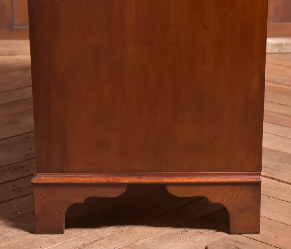 An antique Georgian mahogany kneehole desk featuring seven drawers with brass batwing handles, a recessed central cupboard, and shaped bracket feet. View XIX