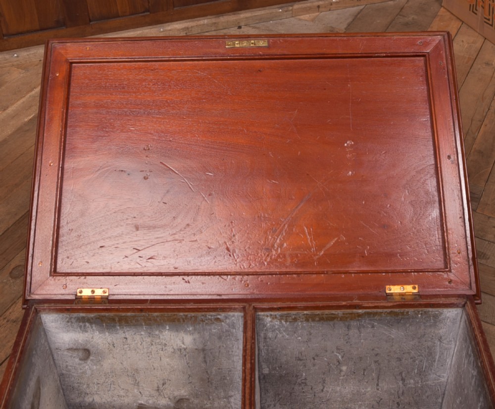 An antique reddish brown mahogany rectangular blanket box featuring a hinged lid, brass side carrying handles, a keyhole, and a moulded plinth base. View VIII