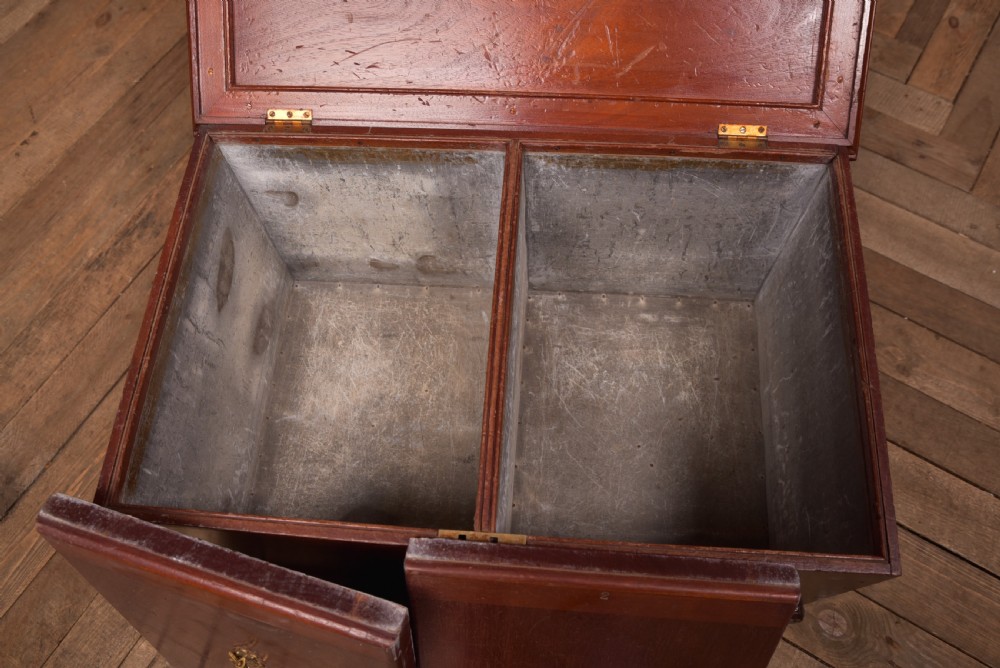 An antique reddish brown mahogany rectangular blanket box featuring a hinged lid, brass side carrying handles, a keyhole, and a moulded plinth base. View XIV