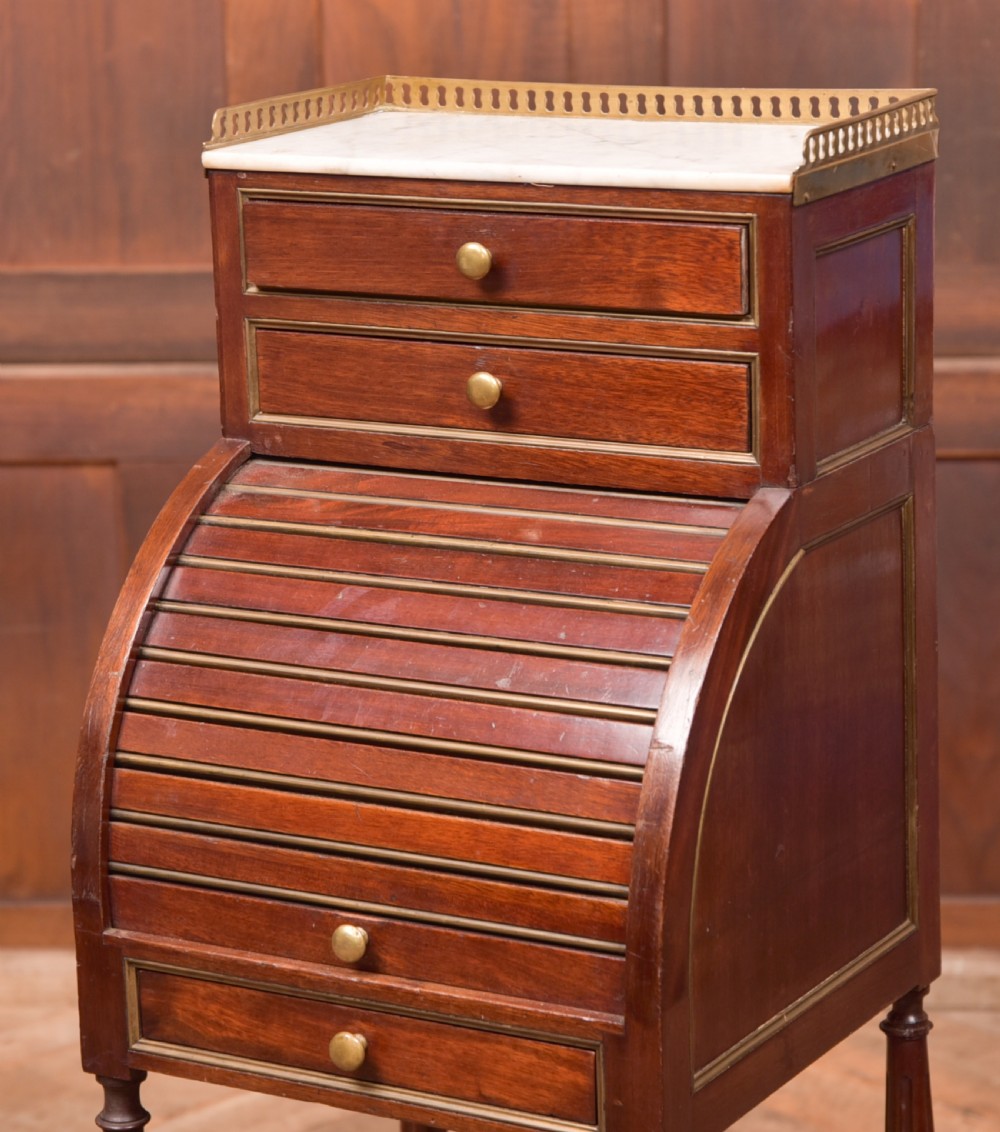 A French mahogany roll-top pot cupboard with a marble top, brass gallery, drawers, slatted tambour front, and turned legs. View II