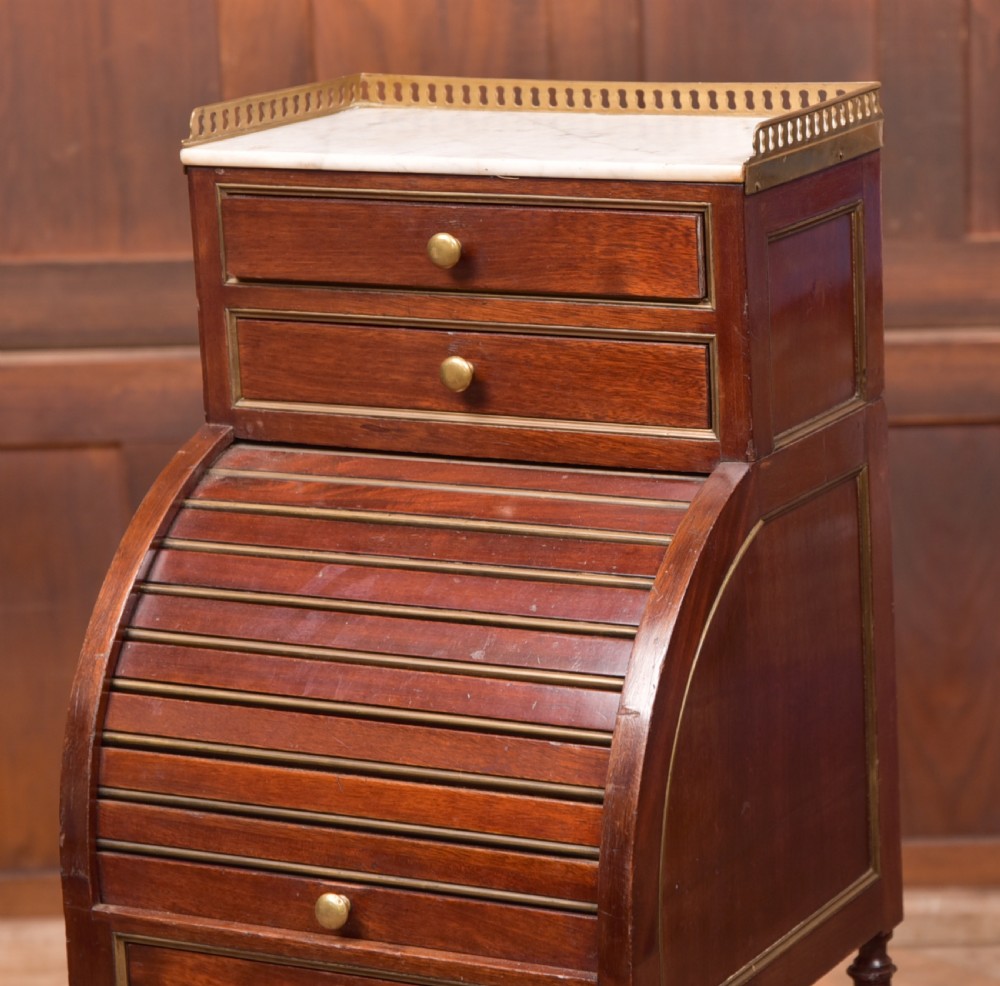 A French mahogany roll-top pot cupboard with a marble top, brass gallery, drawers, slatted tambour front, and turned legs. View III