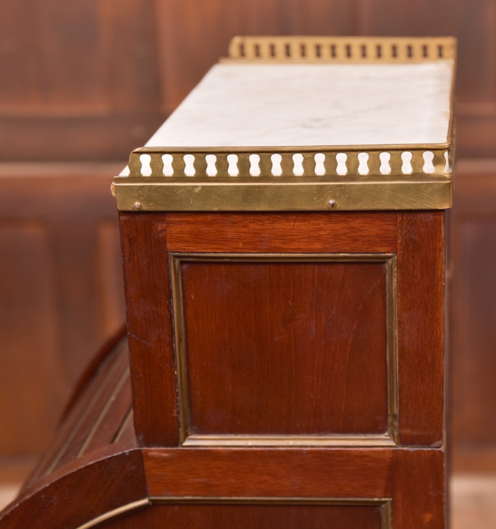 A French mahogany roll-top pot cupboard with a marble top, brass gallery, drawers, slatted tambour front, and turned legs. View VI