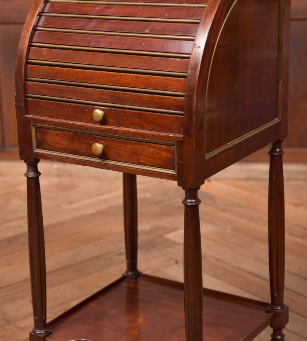 A French mahogany roll-top pot cupboard with a marble top, brass gallery, drawers, slatted tambour front, and turned legs. View XI