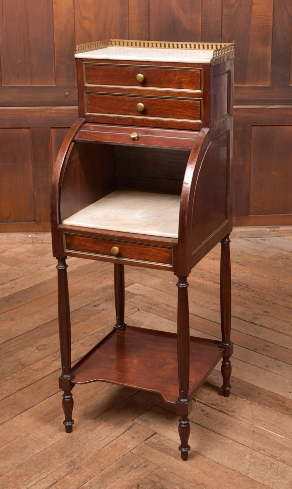 A French mahogany roll-top pot cupboard with a marble top, brass gallery, drawers, slatted tambour front, and turned legs. View XIII