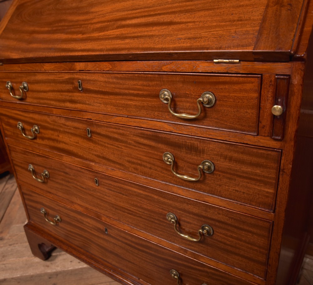 A Georgian mahogany writing bureau featuring a sloped fall-front writing flap above four graduated drawers with brass swan-neck handles and bracket feet. View III