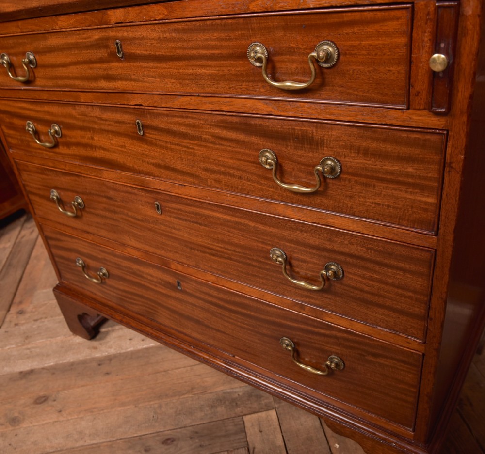 A Georgian mahogany writing bureau featuring a sloped fall-front writing flap above four graduated drawers with brass swan-neck handles and bracket feet. View IV