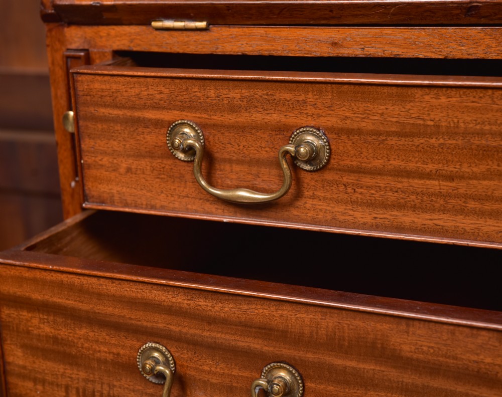 A Georgian mahogany writing bureau featuring a sloped fall-front writing flap above four graduated drawers with brass swan-neck handles and bracket feet. View VII